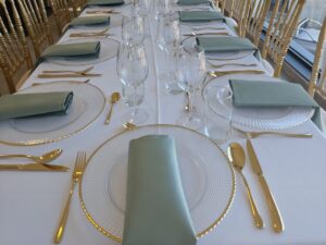 Podtanjiri za iznajmljivanje sa zlatnim escajgom i svetlo zelenim salvetama